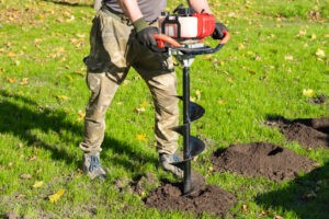 Gardener Using Tools Hand Held Soil Hole Drilling Machine Or Portable Manual Earth Auger.