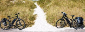 Two Electric Bicycles On A Dike With A Path To The Beach