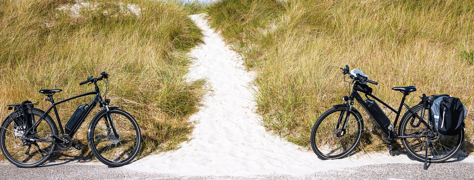 Two Electric Bicycles On A Dike With A Path To The Beach