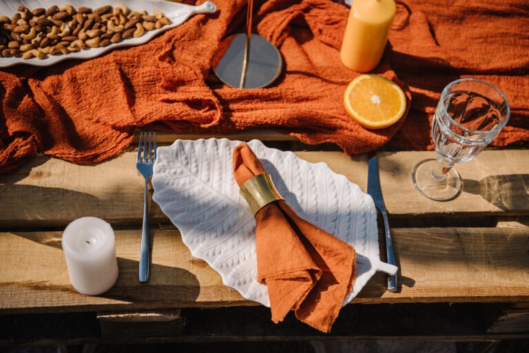 Picnic With Food, Wooden Decor, Candles. Bachelorette Party On Beach. Boho Style Design Picnic. Decorations For Birthday. Wedding Outdoors. Summer Spring Picnic With Blanket, Orange Napkins. Top View